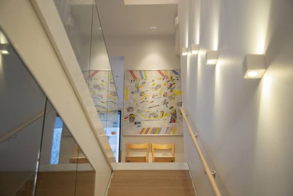 Porrasvalaistuksena ylöspäin ja alaspäin valaisevat seinävalaisimet XL Cubic valkoinen, CCT, tauluvalona LINJA5 - LedStore Upp- och nedåtriktad väggarmatur XL Cubic, CCT som trappbelysning, LINJA5 som bordsbelysning © LedStore