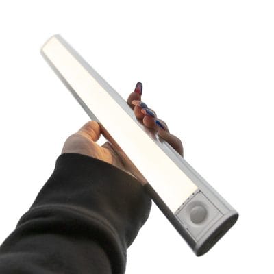 Yksityiskohtainen kuva kädestä, joka pitelee LED-valopalkkia yksiväristä valkoista taustaa vasten. Henkilöllä on pitkät, lakatut kynnet ja yllään tumma hiha. Tämä tuotedemme tyylikkyyttä ja laadukasta viimeistelyä, jotka ovat saatavilla LedStore.fi verkkokaupassa.