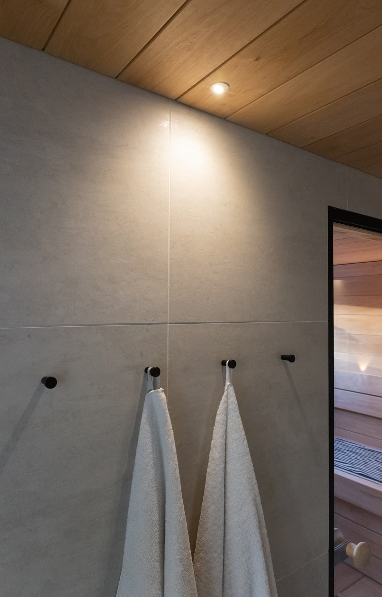 Kylpyhuoneen seinustalla tunnelmavalaisijana saunaspotti Moon. ©LedStore