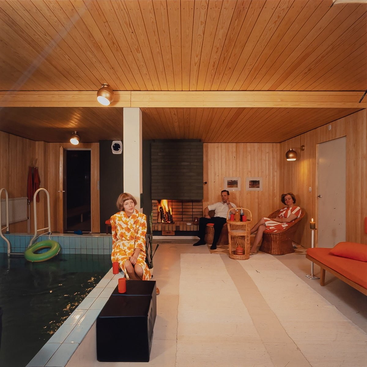 The picture shows a family enjoying their leisure time in the newly renovated, stunning pool and fireplace space. Photo from a client's family album.