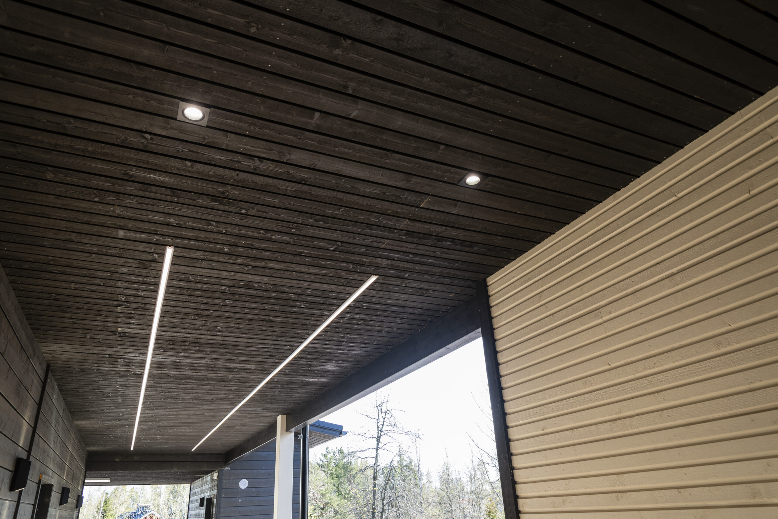 Puisessa katossa upotetut LED-alasvalot sekä LedStore.fi:n LED-pihavalonauhat valaisevat modernin talon ulkotilaa, jossa yhdistyy vaaleat ja tummat julkisivupinnat. - LedStore Sisäänkäyntikäytävällä on kulkua valaisemassa kaksi pitkää led-nauhavaloa rinnakkain. Lisäksi kaksi uppoasennettua led-spottivalaisinta ja seinustalla lisäksi seinävalot.