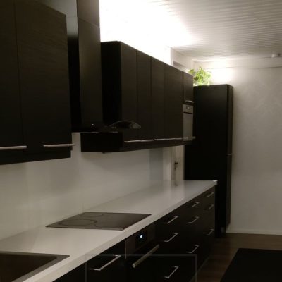 Keittiössä kaappien päällä epäsuoraa valoa led nauhoilla, valo suunnattuna kattoon. Ledstore.fi