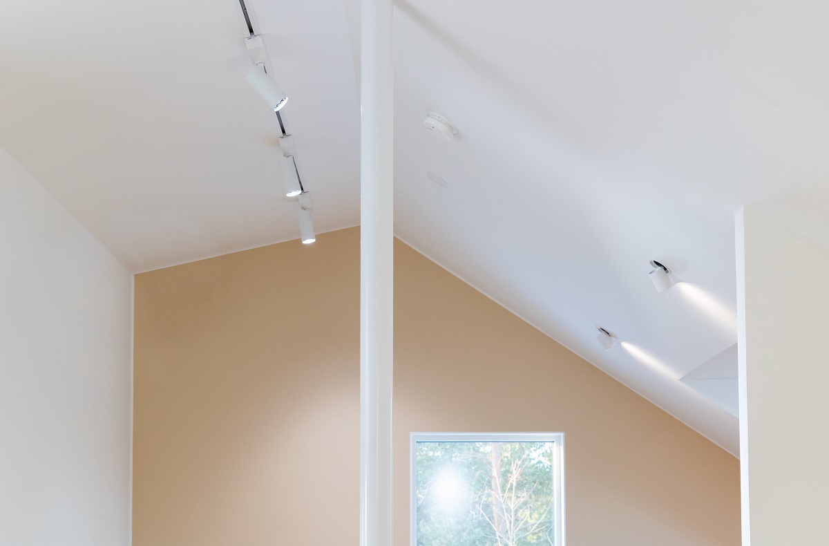 Minimalistinen sisustus, jossa beige vino katto ja valkoiset LedStore.fi:n led-spottivalot kiskoilla takaavat optimaalisen valaistuksen sijoittelun. Ikkunasta avautuu näkymään puustoon. - LedStore Minimalistinen sisustus, jossa beige vino katto ja valkoiset LedStore.fi:n led-spottivalot kiskoilla takaavat optimaalisen valaistuksen sijoittelun. Ikkunasta avautuu näkymään puustoon.