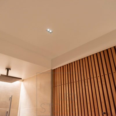 LINJA 2 kylpyhuoneen katossa kapeakeilaisena spottivalaistuksena, suihkun takana tunnelmavalaistuksena led nauha valaisemassa epäsuoraa valoa. Ledstore.fi
