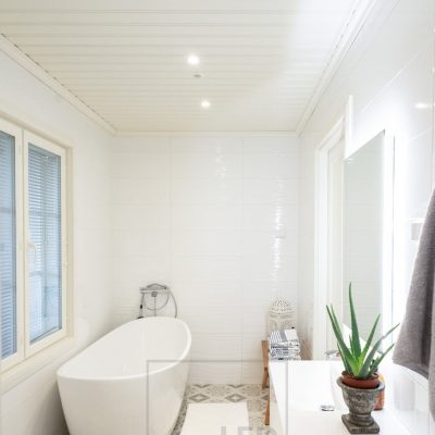 Kylpyhuoneessa valkoiset spotit kattovalaistuksena ja seinällä valpeili valaisemassa seinän kautta epäsuoraa valoa. Ledstore.fi