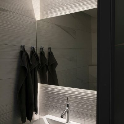Peilin takana led nauhat valaisemassa kylpyhuoneeseen epäsuoraa valoa. Valonauhat korostavat myös teksturoitua laattaa. Ledstore.fi