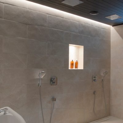 Pesuhuoneen valaistuksena epäsuoraa valoa katon ja seinän välissä ja shampoohyllyssä. Ledstore.fi
