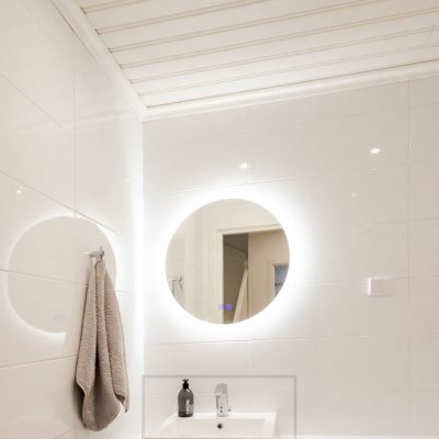 Pyöreä valopeili ja spotti valaisemassa kylpyhuonetta. Valopeili valaisee seinän kautta ja spotti suoraan alas. Ledstore.fi