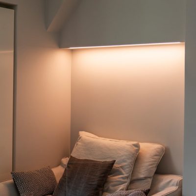 Makuuhuoneessa värilämpötilasäädettävä tunnelmavalaistus sängyn yläpuolella, led nauha kiinnitettynä kaapin pohjaan matalassa pintaprofiilissa. Valo on lämpimän sävyistä kuvassa. Ledstore.fi