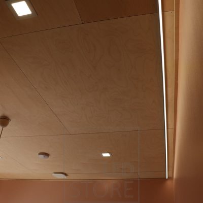 Paneelivalaisimia ja epäsuoraa valoa olohuoneessa, keskellä tilaa sisustuksellinen kattovalaisin. Ledstore.fi