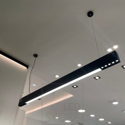 Ledstorella Viiva-valaisin myyntitiskin yläpuolella. Led nauha kattolistan korvaavassa alumiiniprofiilissa valaisemassa epäsuoraa valoa ja katossa esillä spotteja sekä paneeli-valaisimia. Ledstore.fi