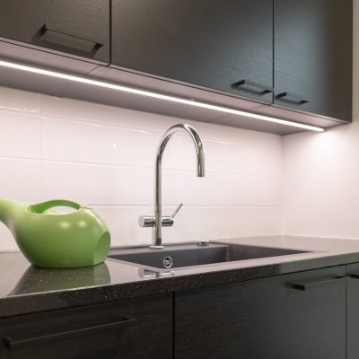 Kodinhoitohuoneen työtasolla tumman pinnan valaisee led-nauha mustassa alumiiniprofiilissa. ©LedStore