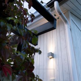 CUBIC OUT 2 talon seinässä valaisemassa kahteen suuntaan lämmintä, tunnelmallista valoa. Ledstore.fi