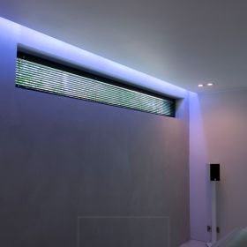 Värisäädettävä RGB+W led nauha luomassa epäsuoraa tunnelmavalaistusta katon ja seinän välisestä urasta. Ledstore.fi