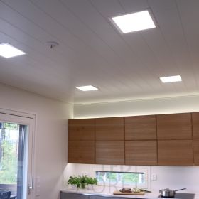 Paneeli-valaisimet katossa, epäsuora valaistus kaappien päällä ja keittiön tasoa valaisemassa led nauha. Ledstore.fi