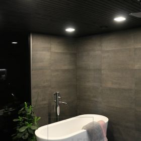 Tummassa, tunnelmallisessa kylpyhuoneessa pienet neliön malliset paneeli-valaisimet. Ledstore.fi