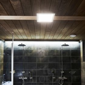 Kylpyhuoneessa paneelivalaisin katossa ja suihkujen takana led valonauha listan takana valaisemassa epäsuoraa valoa. Ledstore.fi