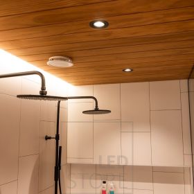 Kylpyhuoneessa mustat spotit yhdistettynä katon ja seinän väliin asennettuun epäsuorasti valaisevaan led nauhaan. Ledstore.fi