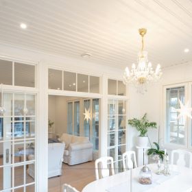 Led spottivalaistus ruokailuhuoneessa. Valkoiset, pyöreät spotit tilan reunoilla ja kattokruunu ruokapöydän yläpuolella. Ledstore.fi
