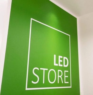 LedStore myymälälogo - LedStore Minimalistinen vihreä seinädesign, jossa valkoinen neliökehys, lihavoitu "LED STORE" isoilla kirjaimilla korostaen modernia LED-valaistusinnovaatiota.