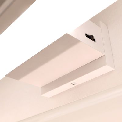 Lähikuva led pelivalosta seinälle asennettuna. Valaisimen kannassa näkyy kytkin.