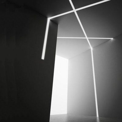 Pimeä minimalistinen huone, joka on valaistu leikkaavilla valkoisilla LED-viivoilla seinillä ja katolla, jotka muodostavat abstraktin geometrisen valokuvion.