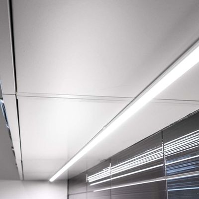 Moderni katto lineaarisella LED-valaistuksella ja heijastavilla hopeapaneeleilla, esittelee nykyaikaista muotoilua energiatehokkaassa valaistuksessa.