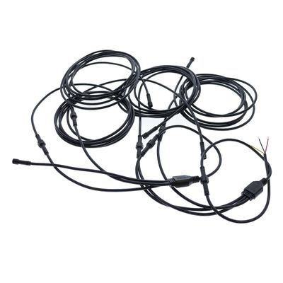 Pitkät LED-valokaapelit, joissa on liittimet ja paljaat johdot, valkoisella pohjalla kierrettyinä valaisimia varten.