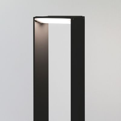 Tyylikäs musta lattiavalaisin, minimalistinen muotoilu, suorakaiteen muotoinen, avoin, pehmeästi hehkuva valkoinen tausta. Täydellinen moderniin LED-valaistukseen.