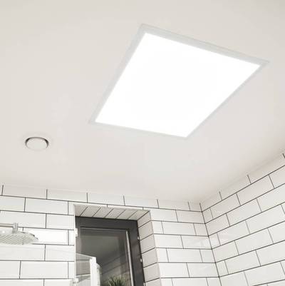 Kirkas LED-paneelivalaisin asennettu valkoiseen kaakeloituun kylpyhuoneen kattoon ikkunalla ja tuulettimella, joka tarjoaa energiatehokkaan valaistuksen.