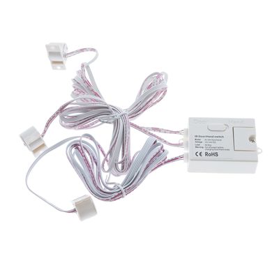 Valkoinen elektroninen ovikytkin johdoilla ja liittimillä, ihanteellinen LED-valaistusasennuksiin, valkoisella taustalla.