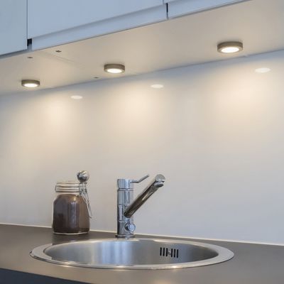 Kolme LED-kaapin alla olevaa valoa valaisevat keittiön modernin hanan ja lasipurkin läheisyydessä olevaa taustalevyä. Kolme LED-kaapin alla olevaa valoa valaisevat keittiön modernin hanan ja lasipurkin läheisyydessä olevaa taustalevyä.