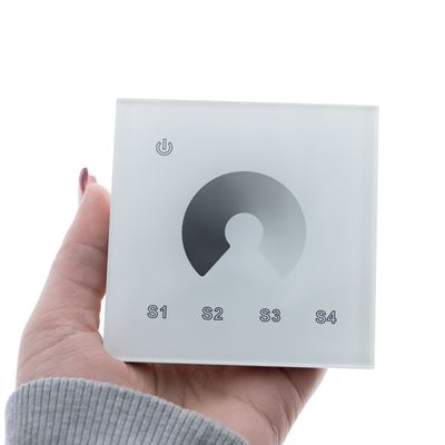 LED-valaistuksen kosketusohjauspaneeli kädessä, virtakuvake sekä painikkeet S1, S2, S3, S4 mukautettavia valoasetuksia varten.