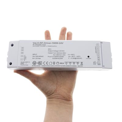 Vaihtoehtoinen teksti: "Kädessä pitävä VaLO-RF-Driver-100W-24V LED-ohjain, jossa on ohjauspainikkeet ja yksityiskohtaiset tekniset tiedot tehokkaaseen LED-valaistukseen.