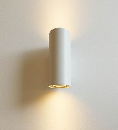 Tyylikäs sylinterimäinen LED-seinävalaisin valaisee lämpimiä valonsäteitä ylös ja alas valkoiselle seinälle; ihanteellinen moderniin, minimalistiseen sisustukseen.