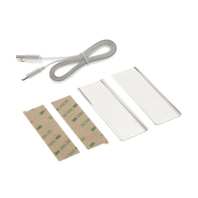 LED-valaistuksen asennussarja: USB-kaapeli, liimanauhat ja suorakaiteen muotoiset valkoiset muoviosat valkoisella pohjalla.