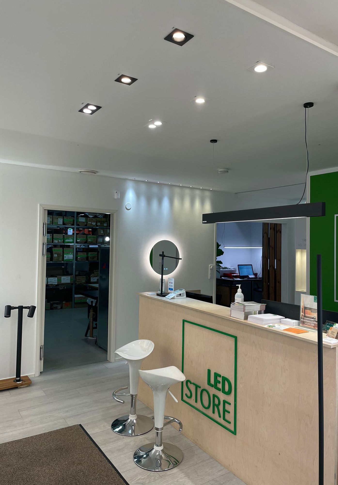 Led valoja Ledstoren Showroomilla. Spotit esillä katossa tiskin edessä ja tiskin yläpuolella VIIVA-kattovalaisin. Seinää korostamassa 3W spottisarjat, kiinteä sekä suunnattava. Spottien alla Moon 600 valopeili. Ledstore.fi