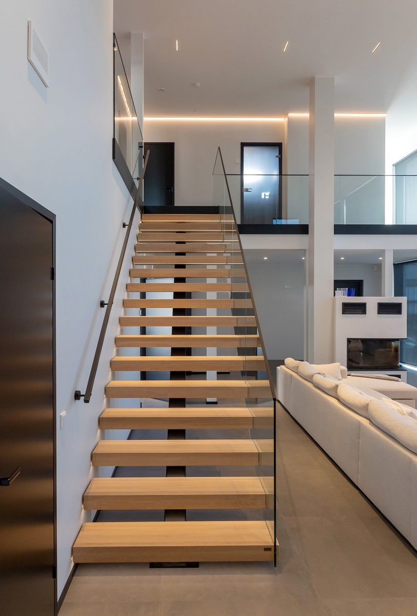 Yläkertaan vievät vaaleat puuportaat valaistu led nauhalla ja ylätasanteella seinän viertä kiertää led nauha