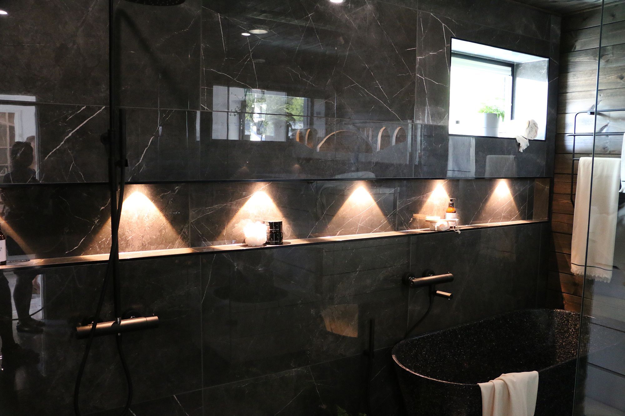 Kylpyhuoneessa spotit korostamassa shampoohyllyä. Ledstore.fi