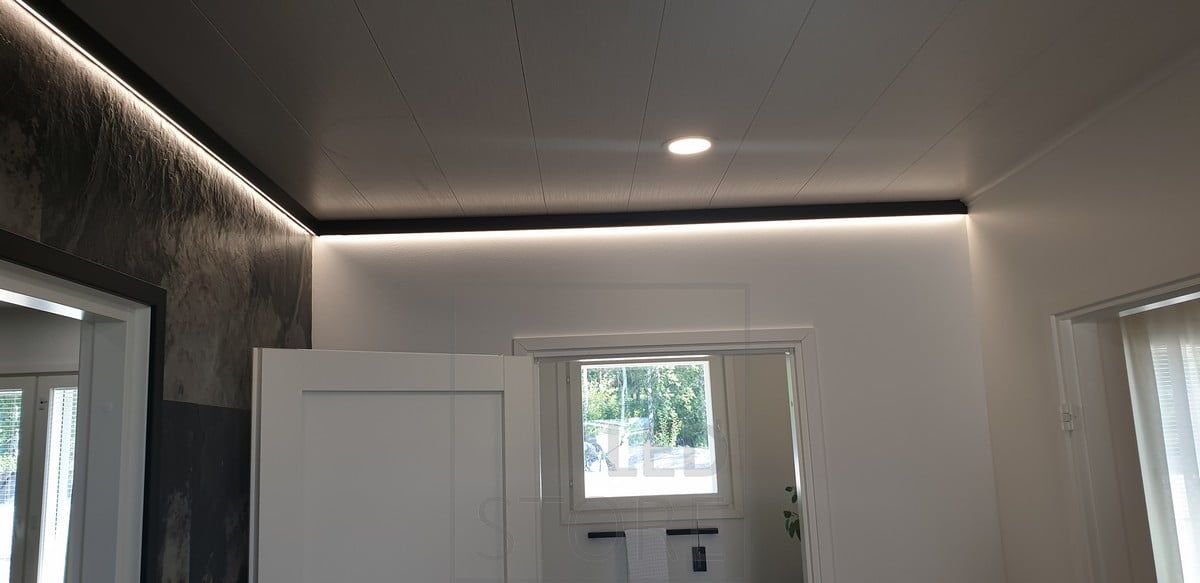 Sisustuksellisessa, mustassa seinäprofiilissa led valonauha antamassa epäsuoraa valoa. Ledstore.fi