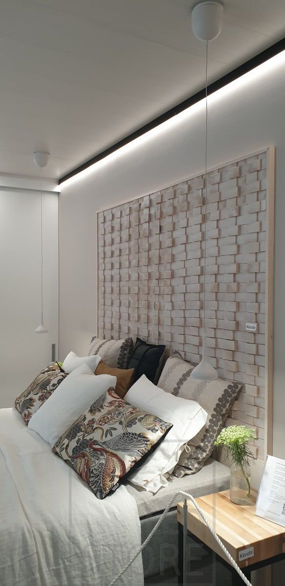 Sängyn takana musta seinäprofiili katon rajassa korvaamassa kattolistan. Led valonauha valaisemassa alaspäin epäsuoraa valoa seinän kautta. Ledstore.fi