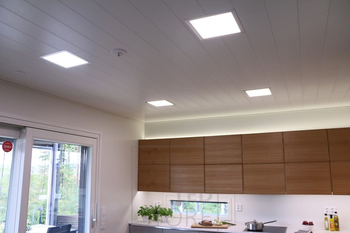 Paneeli-valaisimet katossa, epäsuora valaistus kaappien päällä ja keittiön tasoa valaisemassa led nauha. Ledstore.fi