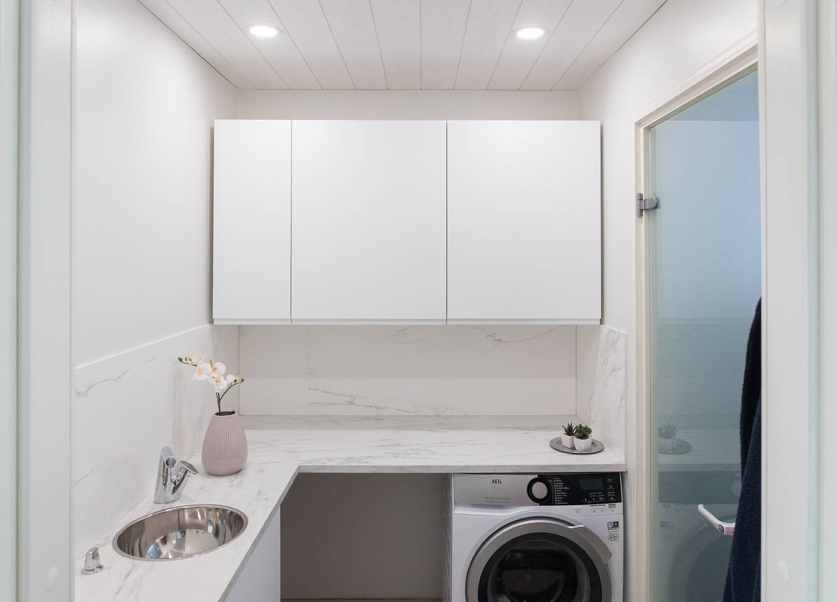 Kodinhoitohuoneen katossa pieniä pyöreitä paneelivalaisimia uppoasennettuna.