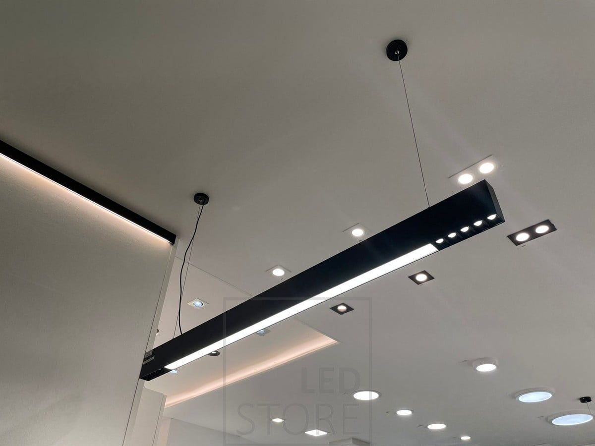 Ledstorella Viiva-valaisin myyntitiskin yläpuolella. Led nauha kattolistan korvaavassa alumiiniprofiilissa valaisemassa epäsuoraa valoa ja katossa esillä spotteja sekä paneeli-valaisimia. Ledstore.fi