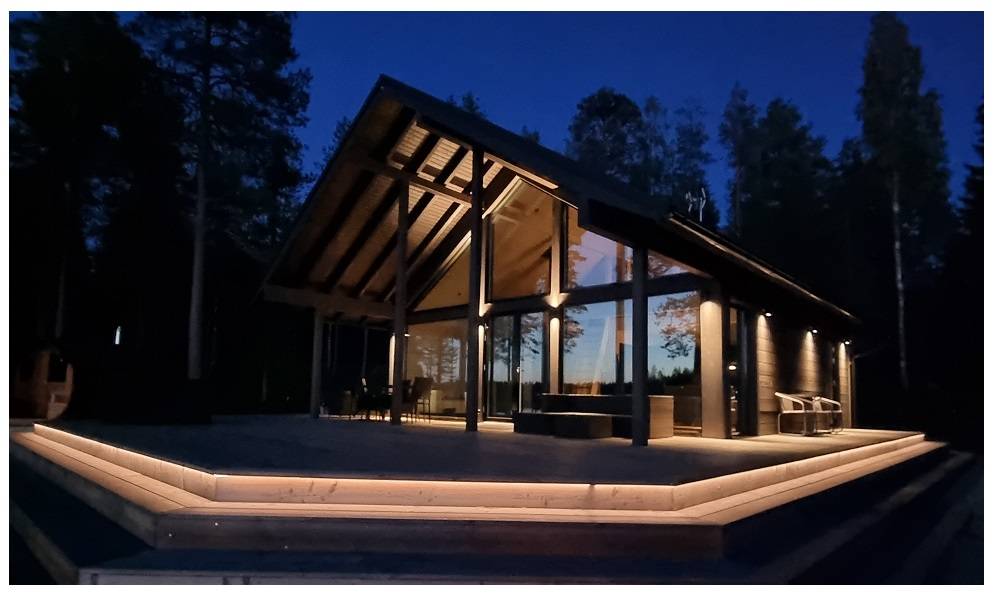 Valaistu LED valonauha kiertää suuren terassin reunaa iltahämärässä