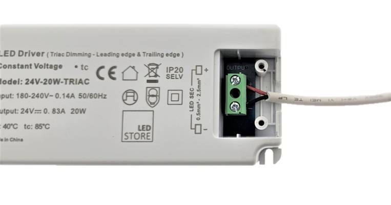 Kuvassa LEd-nauhan punainen plus johto ja musta miinus johto kiinnitettynä led-muuntajaan