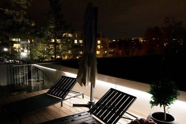 Terassivalaistuksen kaiteen alla led nauha valaisemassa epäsuorasti.