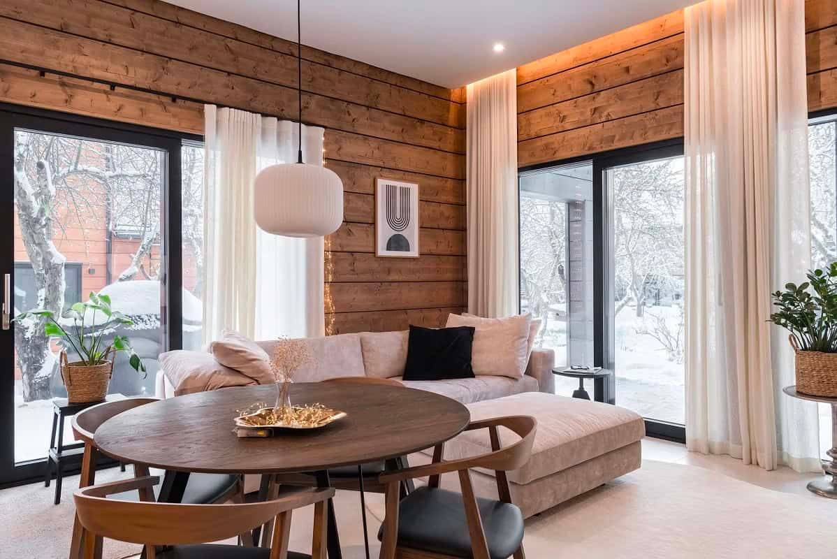 Moderni ja lämmin olohuone, jossa LedStore.fi alaslasketut LED-valot korostavat puupintoja ja tilan arkkitehtuuria.