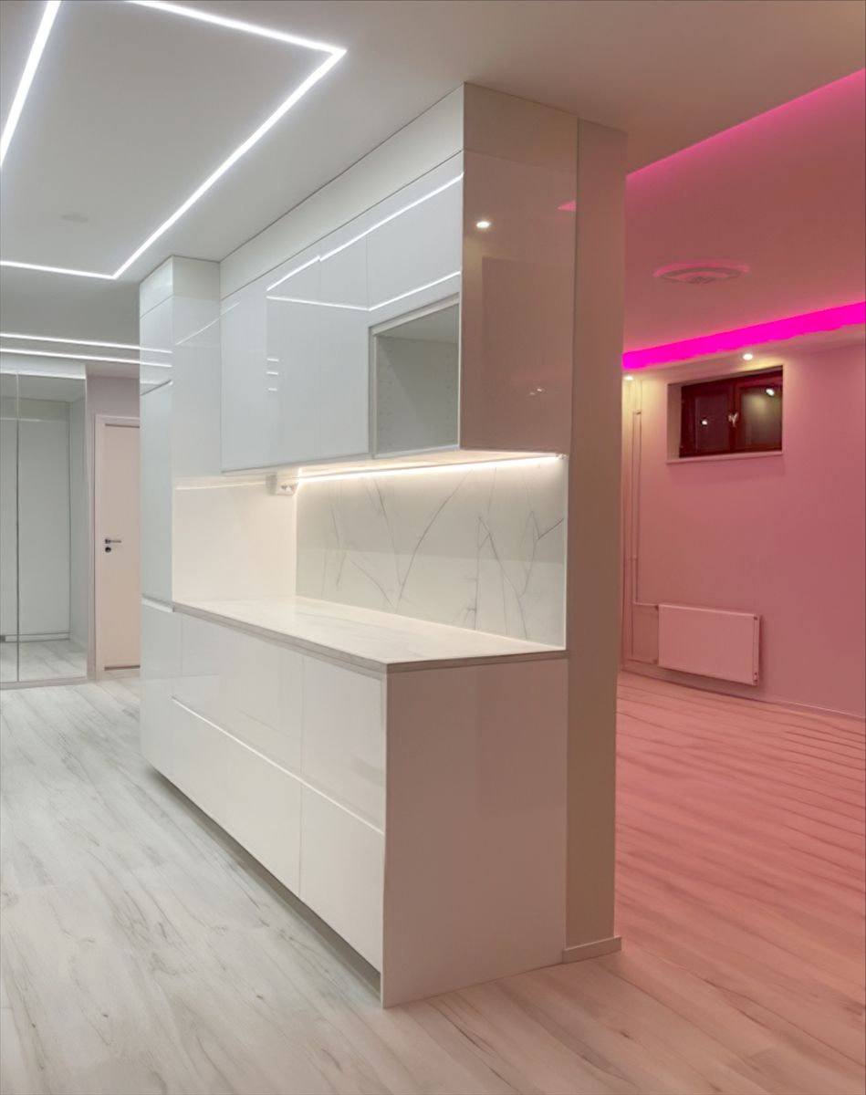 Neliskanttinen valoviiva keittiön katossa ja pinkki led valo olohuoneessa.